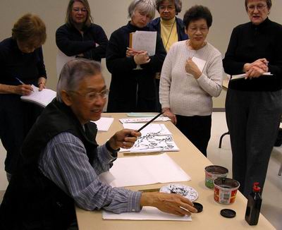 Charles Leung discusses brushes and paper with workshop participants