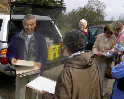Artists receive their outdoor painting kits from Charles Leung