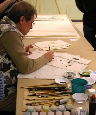 Midge Prong works with two brushes on fine line paper