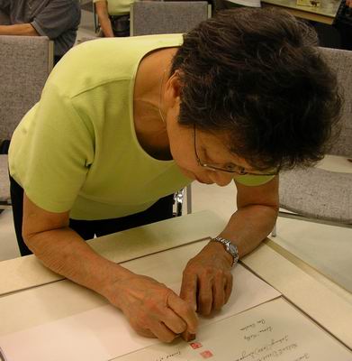 Shirley Isojima signs scroll for Midori Chijiiwa